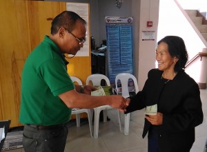 Assistant Regional Director for Administration Francis Khayad handing over the livelihood assistance to one of the parents of the fallen SAF heroes